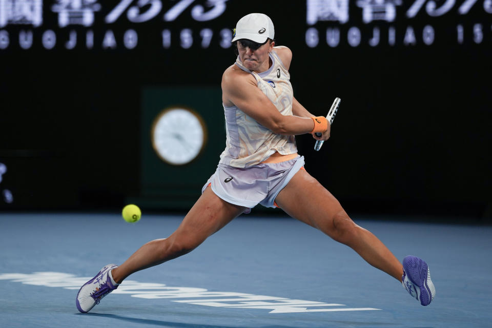 Iga Swiatek of Poland plays a backhand return to Jule Niemeier of Germany during their first round match at the Australian Open tennis championship in Melbourne, Australia, Monday, Jan. 16, 2023. (AP Photo/Aaron Favila)