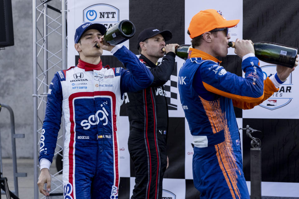 Chip Ganassi Racing driver Alex Palou, from left, Team Penske driver Will Power and Team Penske driver Scott McLaughlin hoist tastes of champaign after they finished first/second/third in the Honda Indy Grand Prix of Alabama auto race at Barber Motorsports Parkway, Sunday, April 18, 2021, in Birmingham, Ala. (AP Photo/Vasha Hunt)