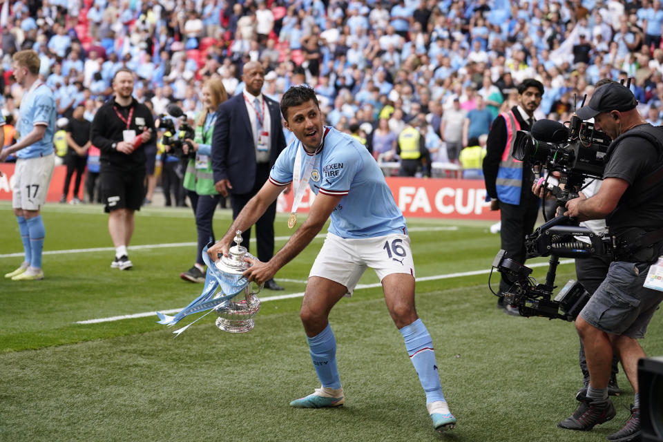 Manchester City's Rodrigo holds the winners trophy as he celebrates winning the English FA Cup final soccer match between Manchester City and Manchester United at Wembley Stadium in London, Saturday, June 3, 2023. Manchester City won 2-1. (AP Photo/Dave Thompson)