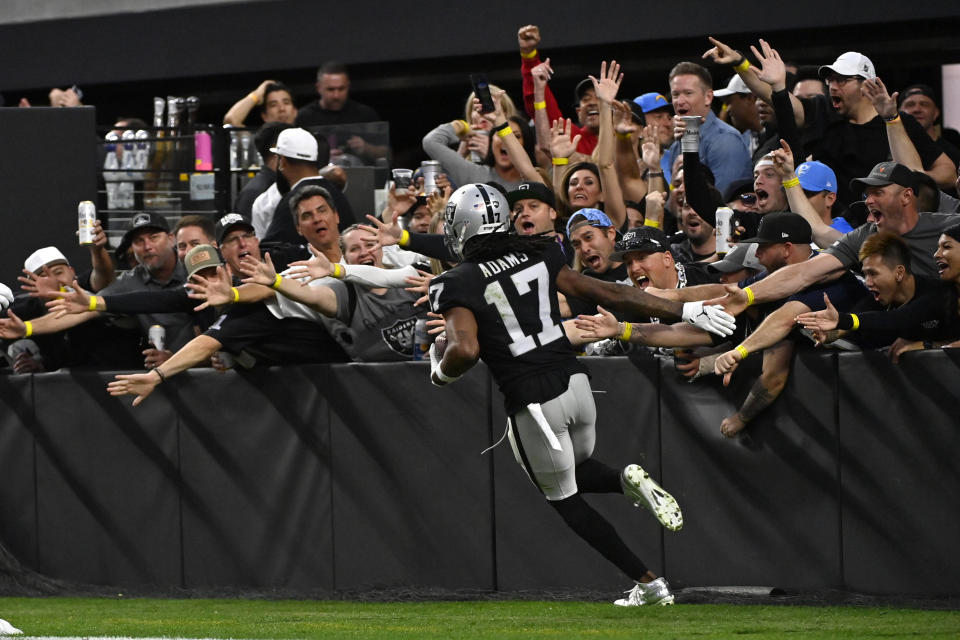 Las Vegas Raiders wide receiver Davante Adams (17) celebrates his touchdown reception as he runs past fans during the second half of an NFL football game against the Los Angeles Chargers, Sunday, Dec. 4, 2022, in Las Vegas. (AP Photo/David Becker)