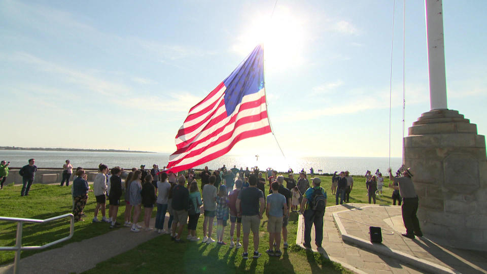 Visitors at Fort Sumter, where the Civil War began, raise the American flag.  / Credit: CBS News