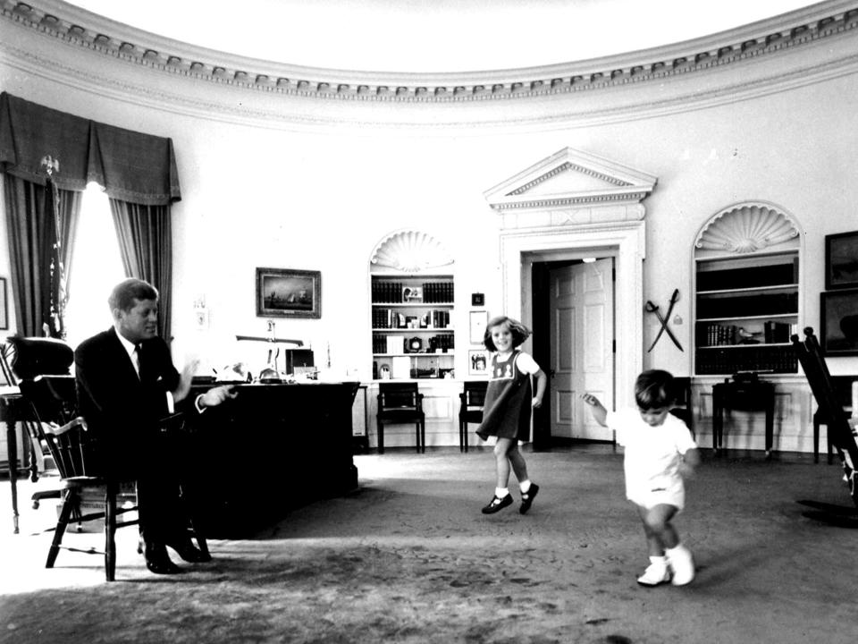 President John F. Kennedy clapping while watching his children dance in the Oval Office in 1963.