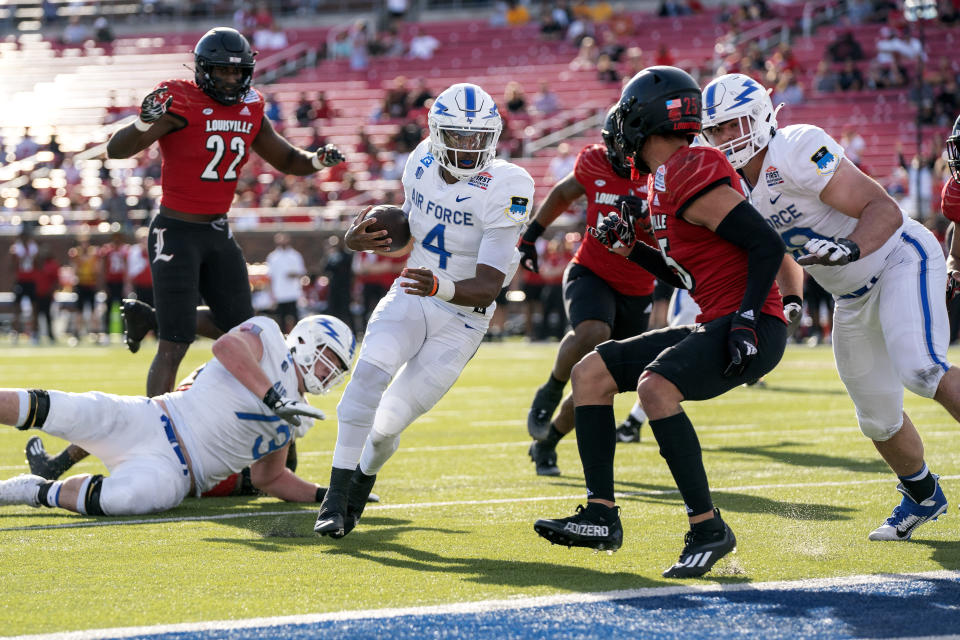 Air Force quarterback Haaziq Daniels (4) runs in for a touchdown as offensive tackle Adam Karas, right, looks to set a block on Louisville defensive back Josh Minkins (25) during the first half of the First Responder Bowl NCAA college football game Tuesday, Dec. 28, 2021, in Dallas. (AP Photo/Jeffrey McWhorter)