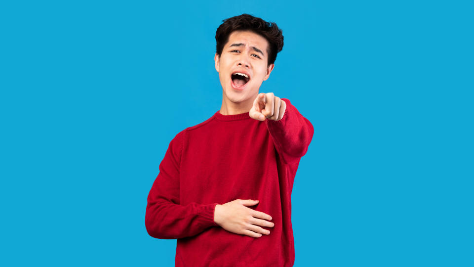 Man in red sweater laughing and pointing