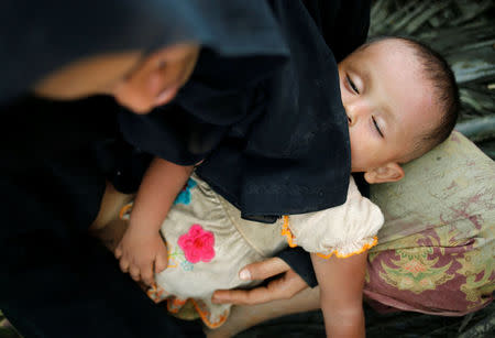 A Rohingya child sleeps on mother’s lap as they wait for boat to cross the border through Naf river in Maungdaw, Myanmar, September 7, 2017. REUTERS/Mohammad Ponir Hossain