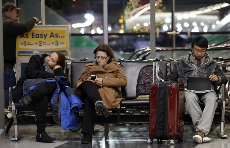 Travelers deal with long waits and flight cancellations at O'Hare International Airport in Chicago on Sunday, Jan. 5, 2014. Temperatures not seen in years are likely to set records in the coming days across the Midwest, Northeast and South, creating dangerous travel conditions and prompting church and school closures. (AP Photo/Nam Y. Huh)
