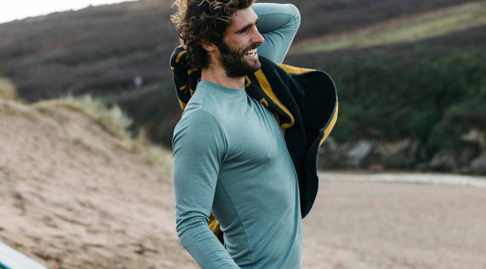 Man wearing Finisterre Eddy base layer at the seaside