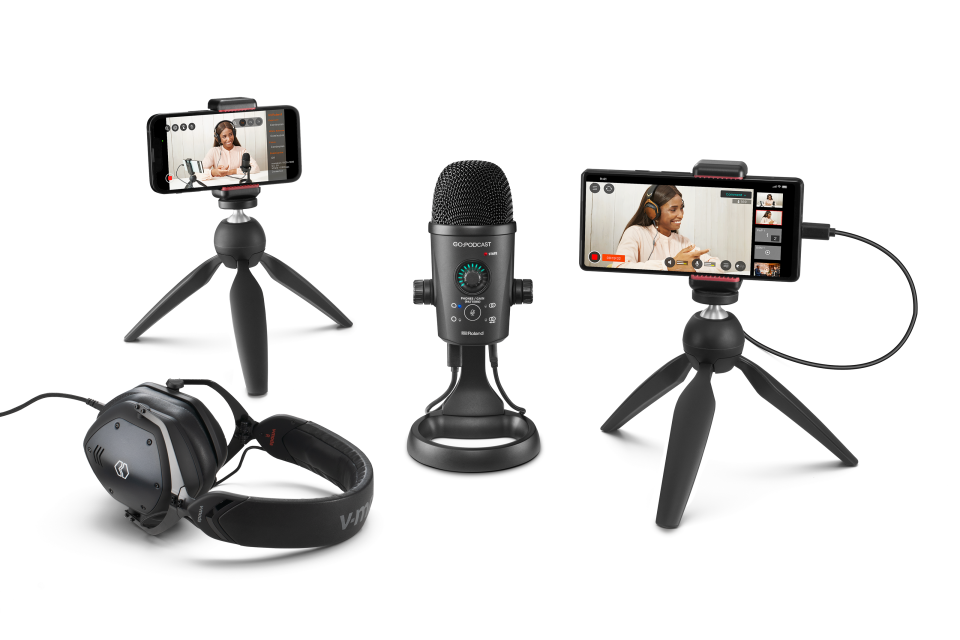Fotografía de marketing de producto para el estudio móvil Rode Go:Podcast.  En el centro hay un micrófono de escritorio, flanqueado por dos teléfonos inteligentes en mini trípodes (que muestran el video del podcast en sus pantallas) y un par de auriculares.