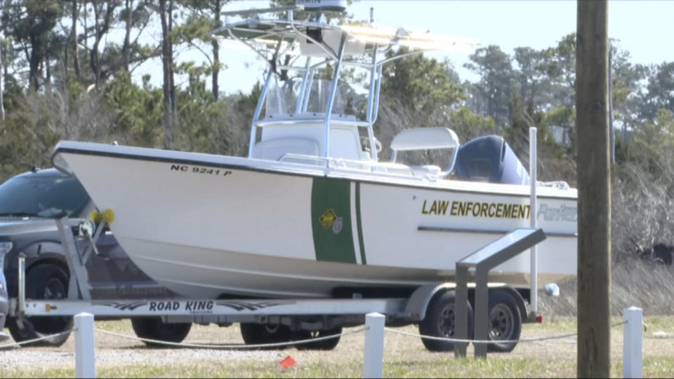 FILE - Law enforcement get ready for a search after a small plane crash in Carteret County, N.C., on Monday, Feb. 14, 2022. The families of four people – including three teens – who died in a February plane crash off the North Carolina coast are suing the companies that owned the plane and employed the pilot, who also died. The suit claims the pilot failed to properly fly the single-engine plane in weather conditions with limited visibility, making the firms liable. All eight people aboard the Pilatus PC-12/47 died when it descended into the Atlantic Ocean off the Outer Banks. (WCTI-TV via AP, File)