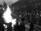 <p>In the streets of London, a crowd of joyous Brits wave flags around a bonfire built of material from bomb-wrecked homes.</p>