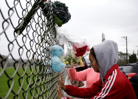 Student Tyanna Davis cries after placing flowers on a fence outside Marysville-Pilchuck High School the day after a shooting at the school in Marysville, Washington October 25, 2014. REUTERS/Jason Redmond