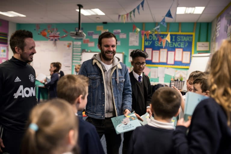 Juan Mata signs copies of Spanish books he distributed during a visit to Royton Hall Primary School through the Manchester United Foundation in Oldham, England on February 19, 2018