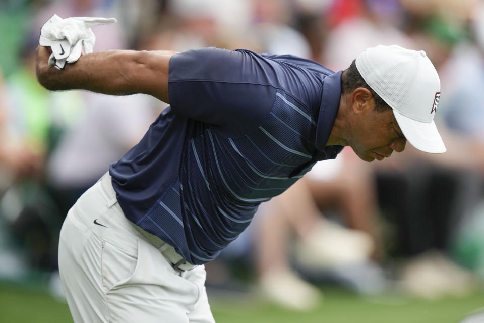 Tiger Woods stretches on the ninth hole during the second round of the Masters golf tournament at Augusta National Golf Club on Friday, April 7, 2023, in Augusta, Ga. (AP Photo/Charlie Riedel)