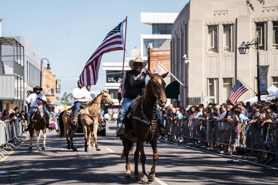 Riders on horseback participate in the bicentennial parade along Main Street in Houma.