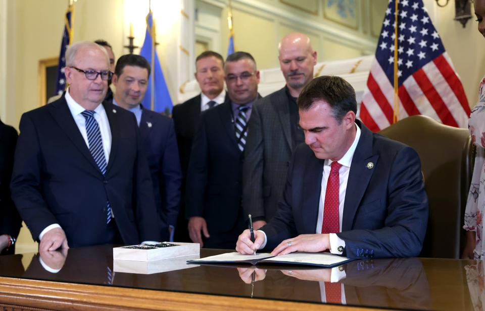 Oklahoma Gov. Kevin Stitt signs an executive order in the Blue Room at the state Capitol in Oklahoma City, Wednesday, Dec. 13, 2023.