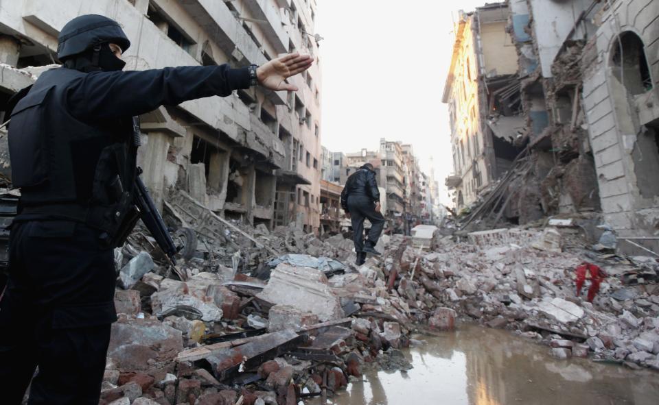 A riot police officer gestures outside the building of the Directorate of Security after an explosion in Egypt's Nile Delta town of Dakahlyia