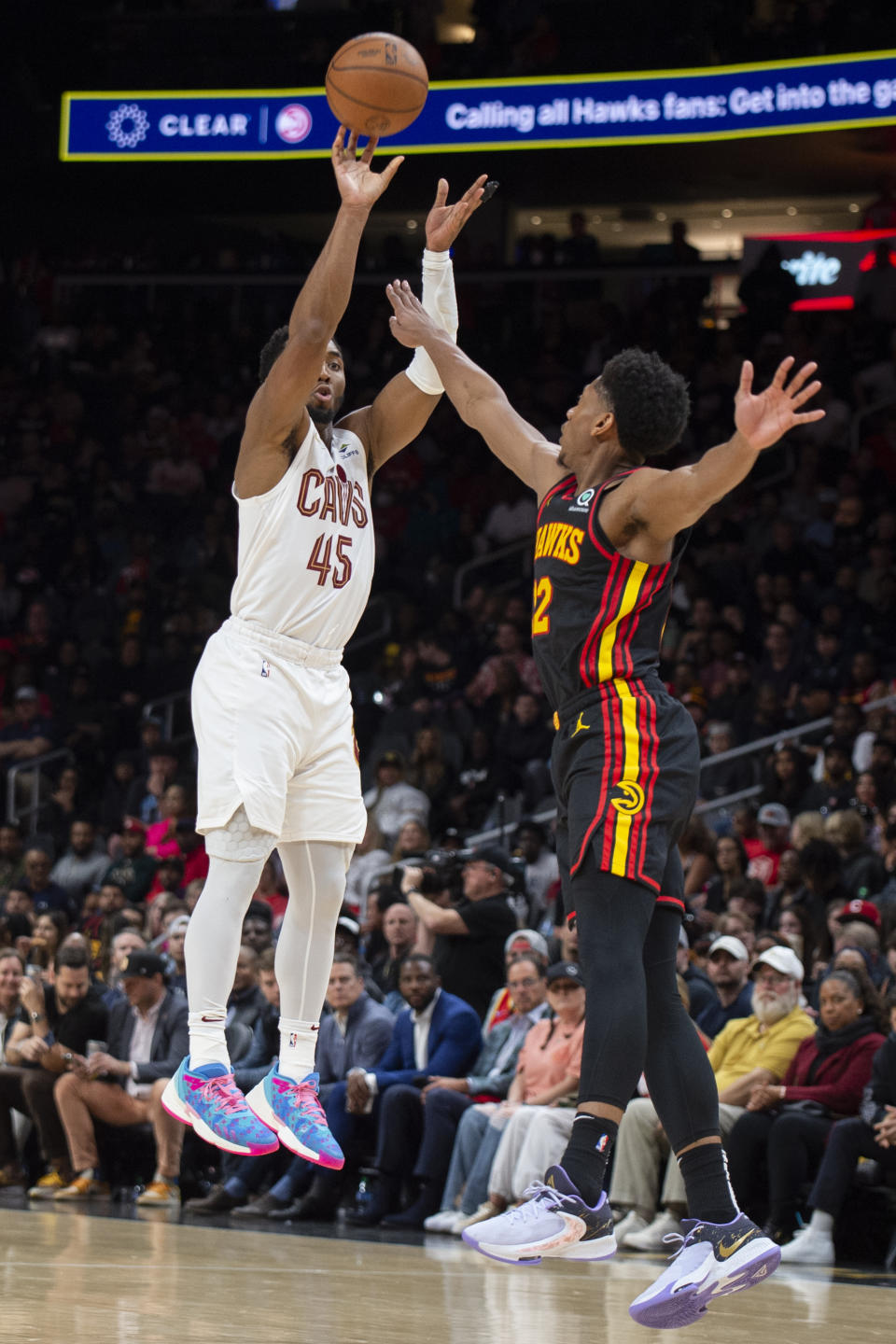 Cleveland Cavaliers guard Donovan Mitchell shoots a three pointer against Atlanta Hawks forward De'Andre Hunter during the second half of an NBA basketball game, Tuesday, March 28, 2023, in Atlanta. (AP Photo/Hakim Wright Sr.)