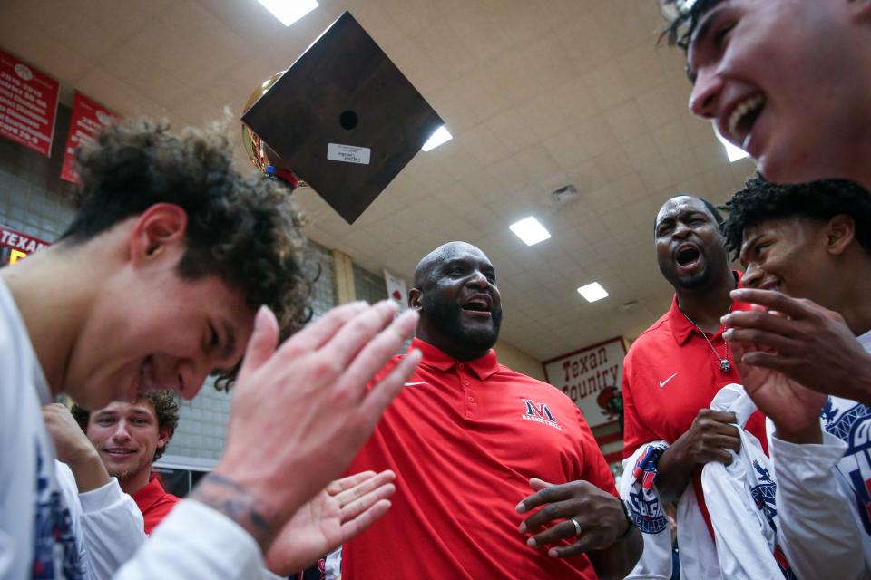 Veterans Memorial head boys basketball coach Billy White Jr. hoists the District 29-5A championship trophy on Tuesday, Feb. 13, 2024, in Corpus Christi, Texas.