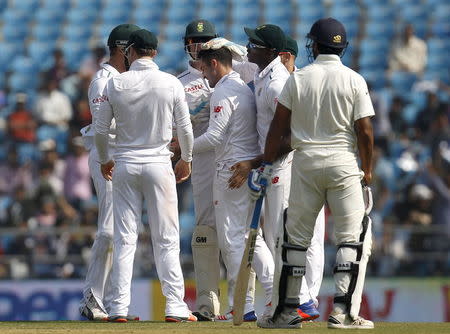 South Africa's Dean Elgar (C) is congratulated by his teammates after he took the wicket of India's Shikhar Dhawan (not pictured) as Murali Vijay (R) watches on the first day of their third test cricket match in Nagpur, India, November 25, 2015. REUTERS/Amit Dave