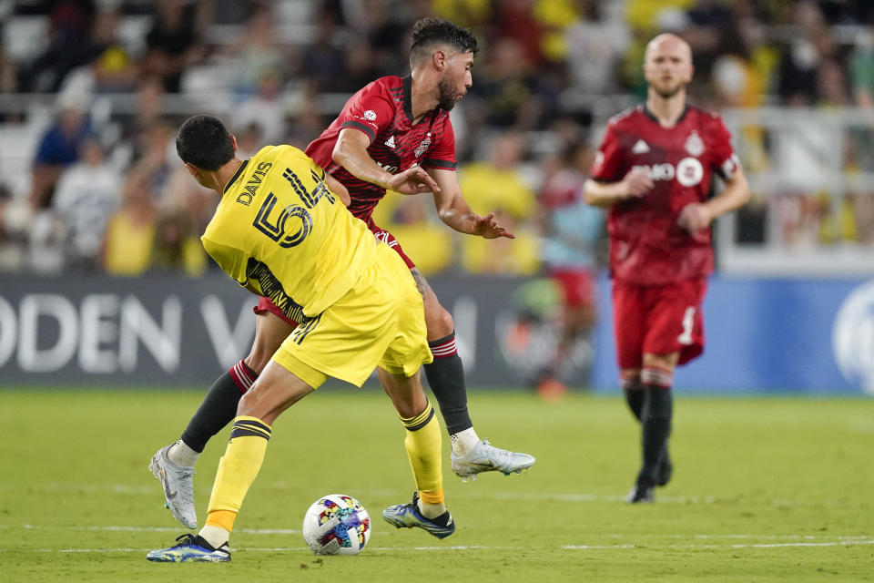 Nashville SC's Sean Davis (54) and Toronto FC's Jonathan Osorio collide during the second half of an MLS soccer match Saturday, Aug. 6, 2022, in Nashville, Tenn. (AP Photo/Mark Humphrey)