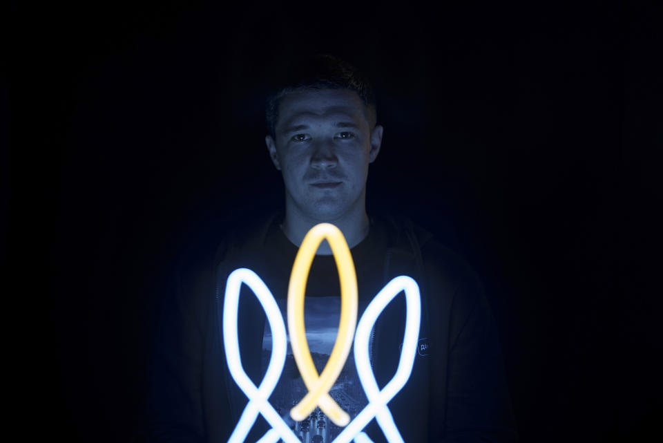 FILE - Mykhailo Fedorov, Ukrainian minister of digital transformation, poses for a photo illuminated by a lamp in the shape of a Ukrainian trident, a national symbol, in his office in Kyiv, Ukraine, Wednesday, Dec. 21, 2022. Fedorov, agrees that fully autonomous killer drones are "a logical and inevitable next step" in weapons development. (AP Photo/Felipe Dana)