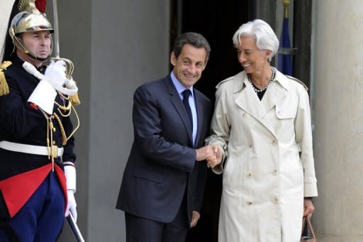 French President Nicolas Sarkozy (C) shakes hands with International Monetary Fund chief Christine Lagarde after a meeting on October 8, 2011. European leaders, including Sarkozy and Lagarde, on Sunday said "good progress" had been made in a summit on the debt crisis