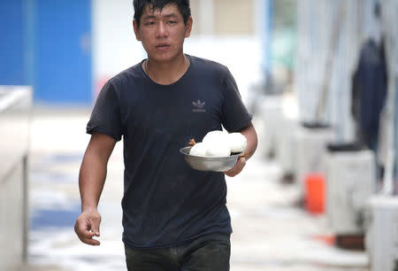 Yu Jinting, 26, from Baoding, Hebei province, carries his lunch at a construction site in Beijing, China July 20, 2017. Picture taken July 20, 2017. REUTERS/Jason Lee