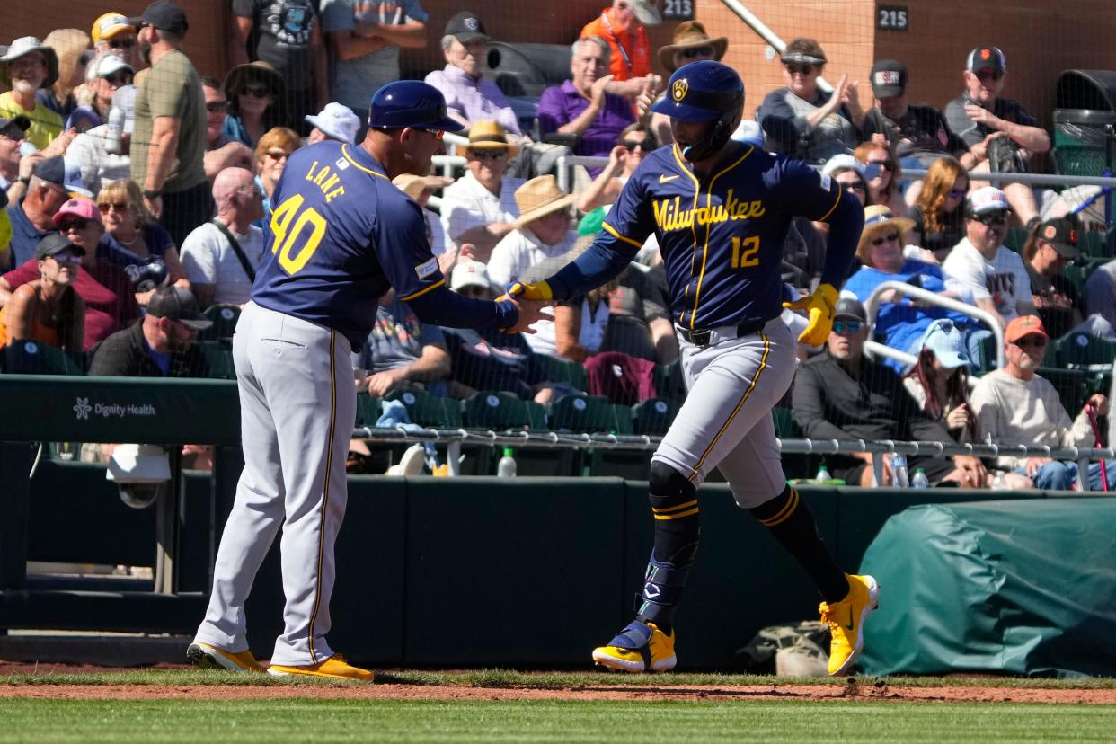 Rhys Hoskins celebrates with third base coach Jason Lane after Hoskins' home run against the Giants on March 5. Hoskins joined the Brewers this offseason and will play first base while also getting some at-bats as DH.