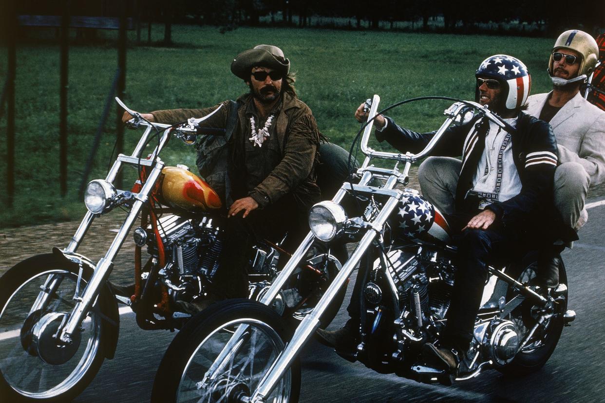 American actors Dennis Hopper, Jack Nicholson and Peter Fonda ride through the countryside on motorcycles in a still from the film 'Easy Rider' directed by Hopper.