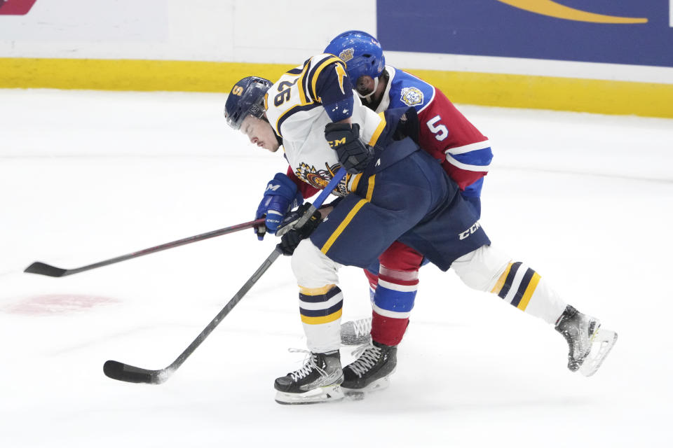 Shawinigan Cataractes' Pierrick Dube, left, and Edmonton Oil Kings' Simon Kubicek get tied up in their skates while fighting for position in the first period of the Memorial Cup hockey game in Saint John, New Brunswick, Tuesday, June 21, 2022. (Darren Calabrese/The Canadian Press via AP)