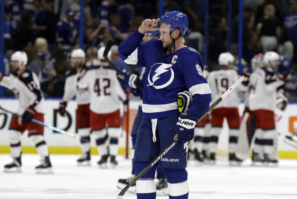 Tampa Bay Lightning center Steven Stamkos (91) skates off as the Columbus Blue Jackets celebrate their 4-3 win during Game 1 of an NHL Eastern Conference first-round hockey playoff series Wednesday, April 10, 2019, in Tampa, Fla. (AP Photo/Chris O'Meara)
