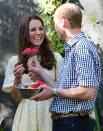 <p>The Duke of Cambridge handed the Duchess a flower during their visit to the Bilby Enclosure at Taronga Zoo in April 2014. The trip marked their first official visit overseas with their newborn son, Prince George. </p>