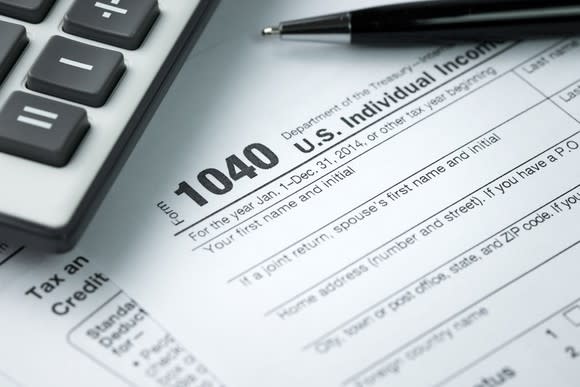 IRS form 1040 with a pen and calculator on top of it