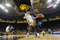 Iowa forward Josh Ogundele (23) is fouled by Michigan center Hunter Dickinson (1) during the first half of an NCAA college basketball game, Thursday, Feb. 17, 2022, in Iowa City, Iowa. (AP Photo/Charlie Neibergall)