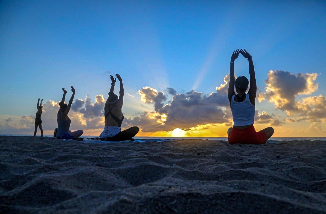 Participants stretch during a sunrise yoga class on the beach in Delray Beach in July.