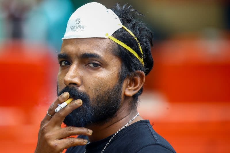 A man wearing an N95 mask smokes a cigarette in Singapore