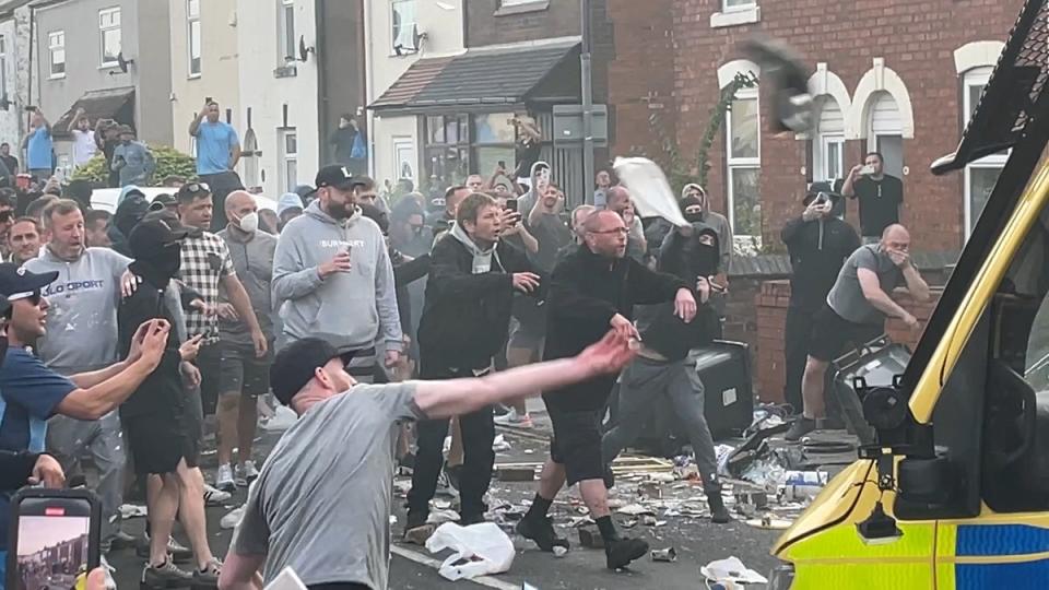 An angry mob threw items at police vans and officers outside a mosque (Richard McCarthy/PA Wire)