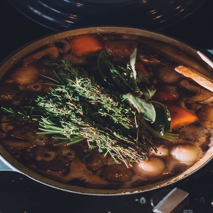 Bundle of fresh, hearty herbs in a stew.