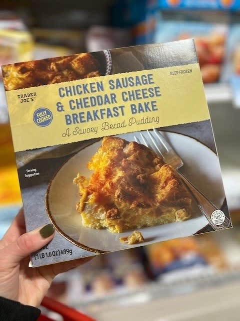 Trader Joe's Chicken Sausage & Cheddar Cheese Breakfast Bake packaging held in a hand with grocery shelves in the background