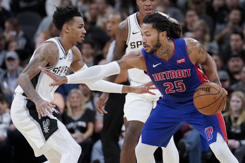 Detroit Pistons' Derrick Rose (25) drives against San Antonio Spurs' Dejounte Murray during the second half of an NBA basketball game Saturday, Dec. 28, 2019, in San Antonio. San Antonio won 136-109. (AP Photo/Darren Abate)