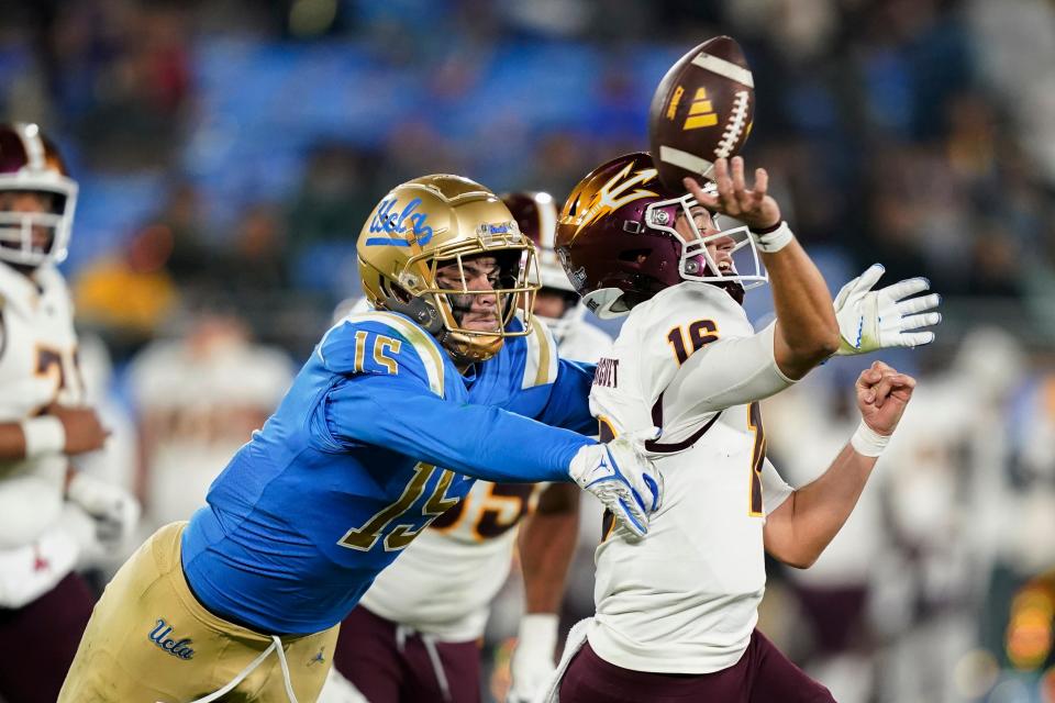 UCLA defensive lineman Laiatu Latu (left) pressures Arizona State quarterback Trenton Bourguet during the second half of an NCAA college football game on Nov. 11 in Pasadena, Calif.