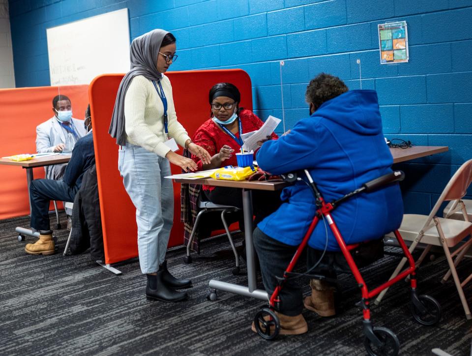 Site coordinator Michelle Denton, center, of the Accounting Aid Society helps tax preparer Taslima Akhtar, left, as she works on taxes for Kathleen Stokes, right, of Detroit, at the Ford Resource and Engagement Center-East in Detroit on Thursday, Jan. 26, 2023.