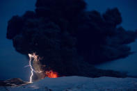 Lighting seen amid the lava and ash erupting from the vent of the Eyjafjallajokull volcano in central Iceland early morning Sunday April 18 2010 as it continues to vent into the skies over Europe. Low-energy lightning is sometimes active during eruptions, arcing between particles as they exit the volcanic vent at around 100 metres per second. The dramatic volcanic eruption which has closed Europe's airspace for days has entered a new phase - producing less smoke but bubbling with lava and throwing up chunks of molten rock. (AP Photo/ Jon Pall Vilhelmsson)