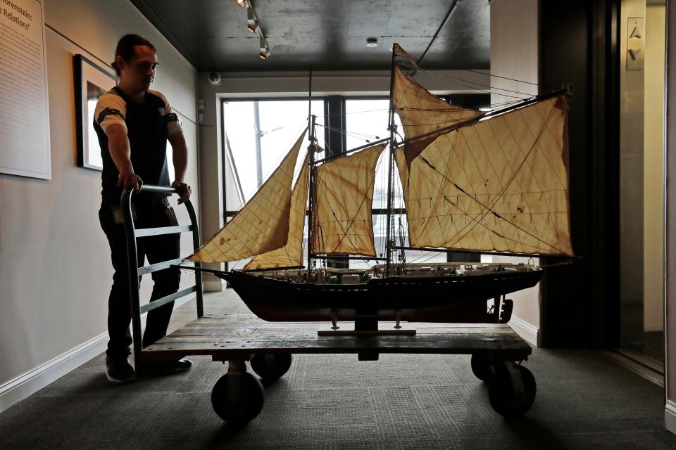 Jacob Mark, curatorial assistant, wheels a model of the schooner Ernestina made by Julio Gomes using popsicle sticks, to be installed on the second floor of the Lagoda room inside the Whaling Museum.