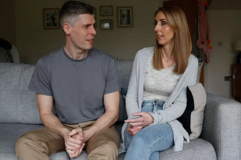 Laura and her husband Duncan sat on a sofa looking at each other