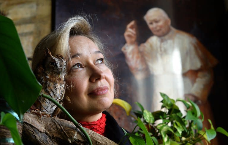 The Vatican's newest official painter, Natalia Tsarkova, poses with her pet owl next to a painting of Pope John Paul II on December 18, 2012 in her studio in Rome. After Michelangelo and Raphael, she is something of an unusual choice