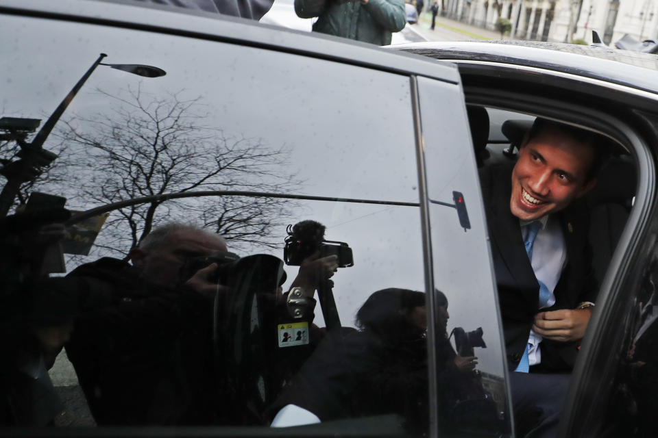 The leader of Venezuela's political opposition Juan Guaido smiles from a car during a visit to Madrid, Spain, Saturday, Jan. 25, 2020. Juan Guaido, the man who one year ago launched a bid to oust Venezuelan President Nicolas Maduro, arrived Saturday in Spain, where a thriving community of Venezuelans and a storm among Spanish political parties awaited him. (AP Photo/Paul White)