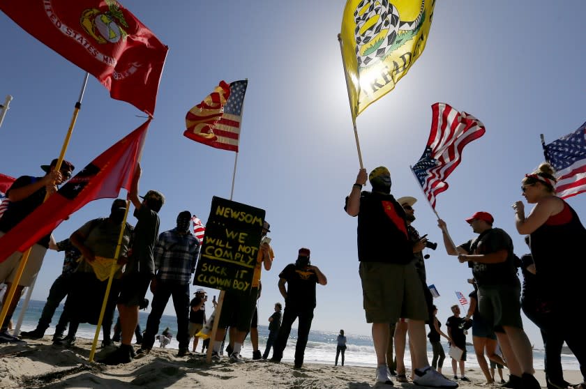 LAGUNA BEACH, CALIF. - MAY 2, 2020. Protesters stage a temporary takeover of the beach in Laguna Beach on Saturday, May 2, 2020. California Gov. Gavin Newson ordered a hard closure of Orange County beaches this weekend. But responding to public pressure in recent days, Newson has implied that a gradual reopening of beaches, parks and the economy following the coronavirus lockdown could begin as early as next week. (Luis Sinco/Los Angeles Times)