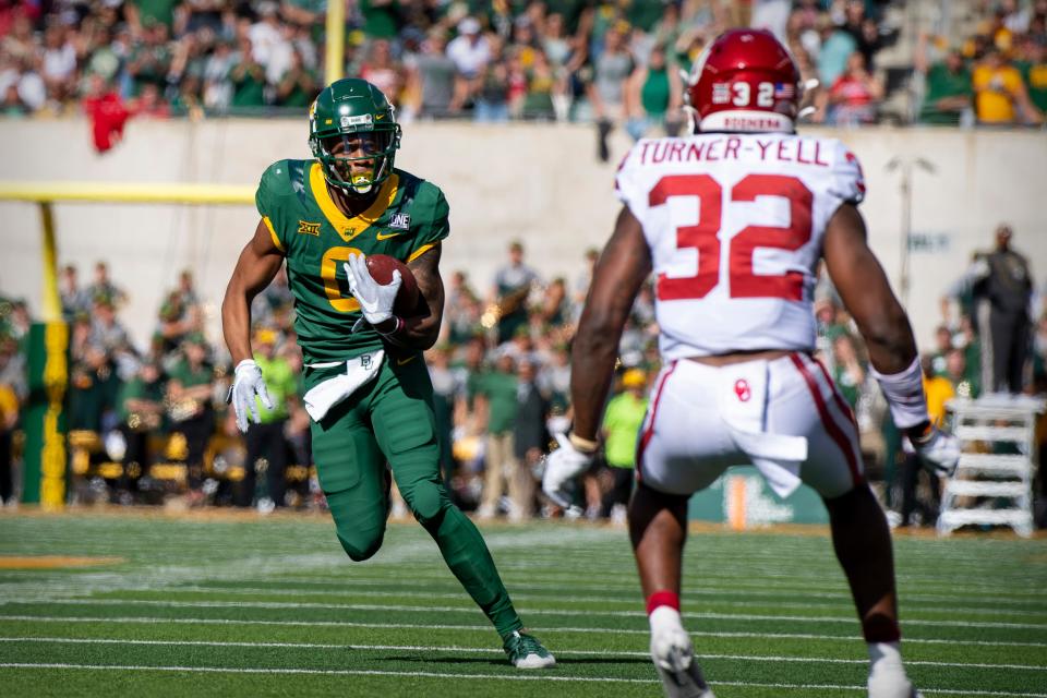 Nov 13, 2021; Waco, Texas, USA; Baylor Bears wide receiver Tyquan Thornton (9) tries to elude Oklahoma Sooners safety Delarrin Turner-Yell (32) during the second half at McLane Stadium. Mandatory Credit: Jerome Miron-USA TODAY Sports