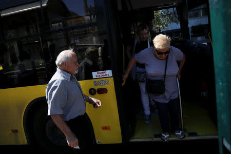 A passenger (L) prepares to board a bus from the front door in central Athens, Greece, August 30, 2018. The sticker reads "Entrance only". REUTERS/Alkis Konstantinidis